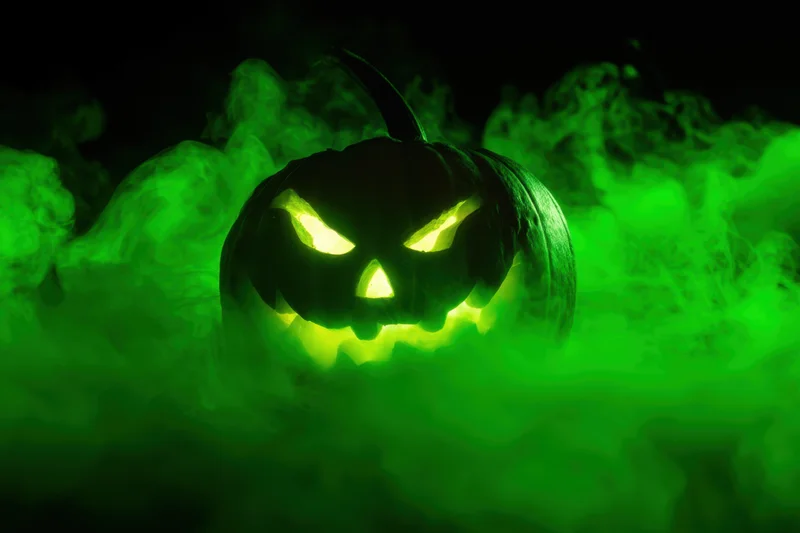 Glowing jack-o-lantern with carved face in green smoke at night