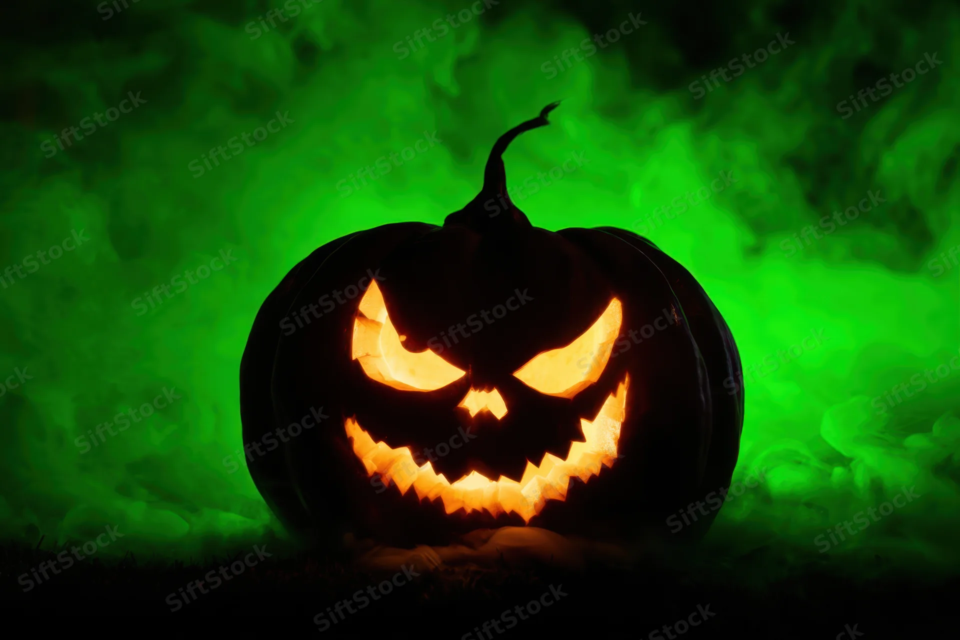 Glowing jack-o-lantern with mischievous carved face in dark foggy setting