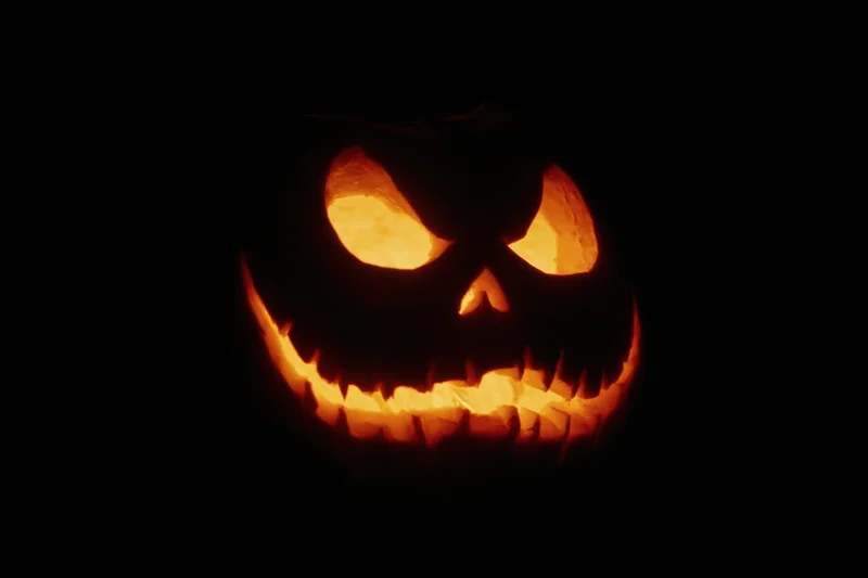 Glowing jack-o-lantern with carved eerie face in dark night