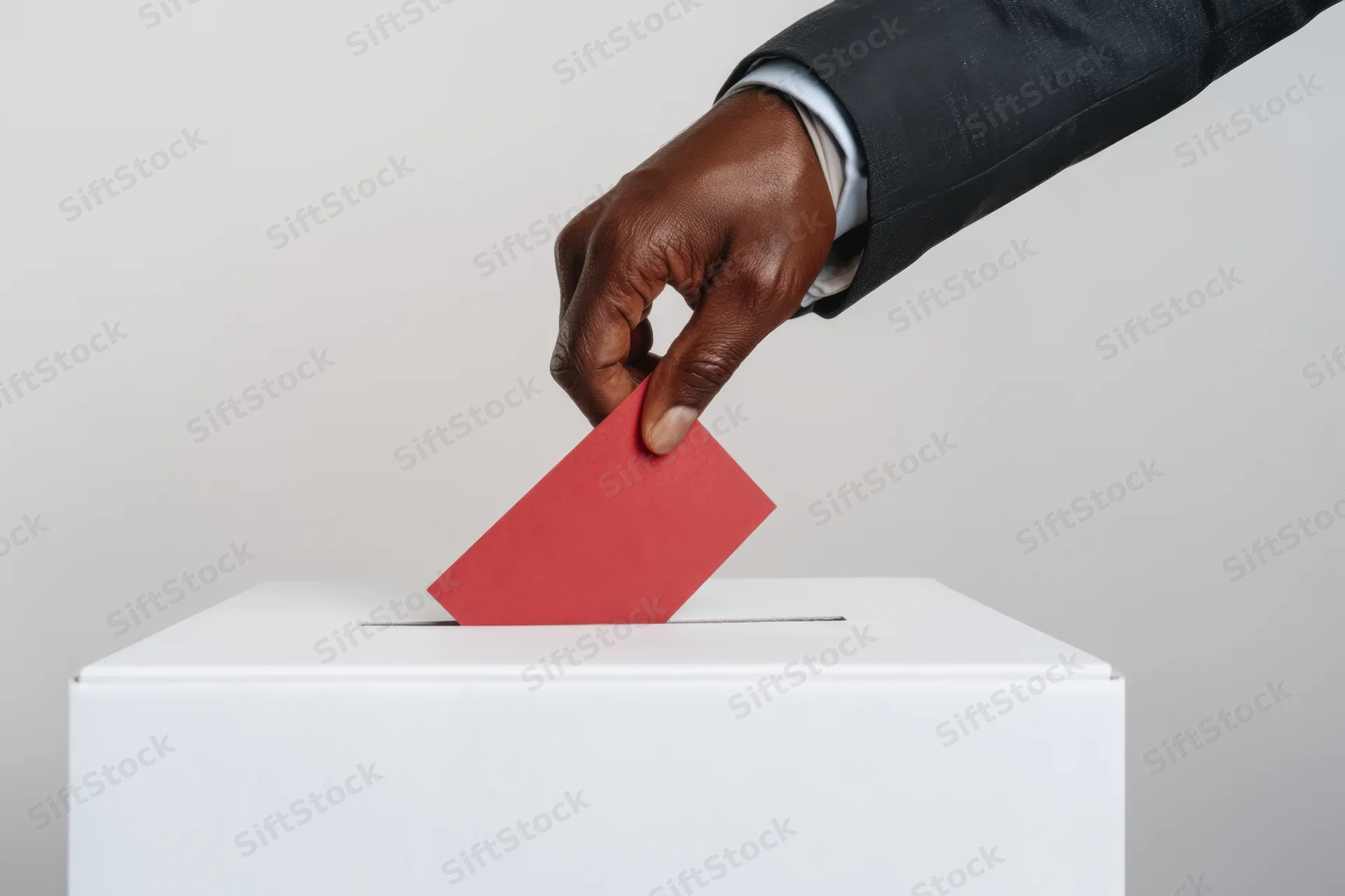 Hand in suit casting red ballot into white box