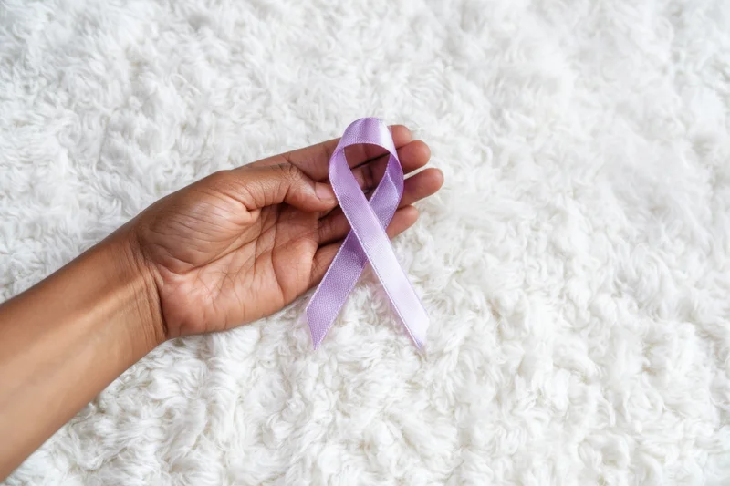 Hand holding lavender ribbon on white fluffy rug