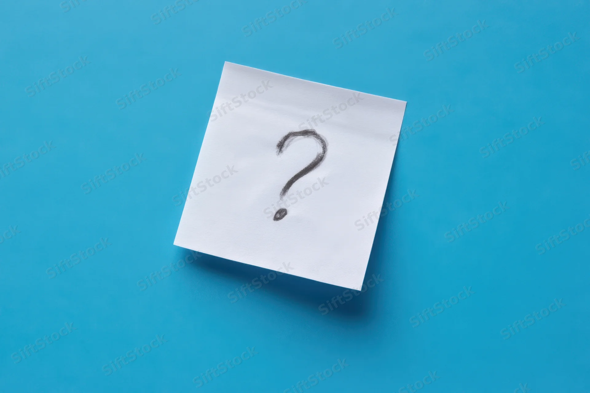 White sticky note with hand-drawn question mark on blue background