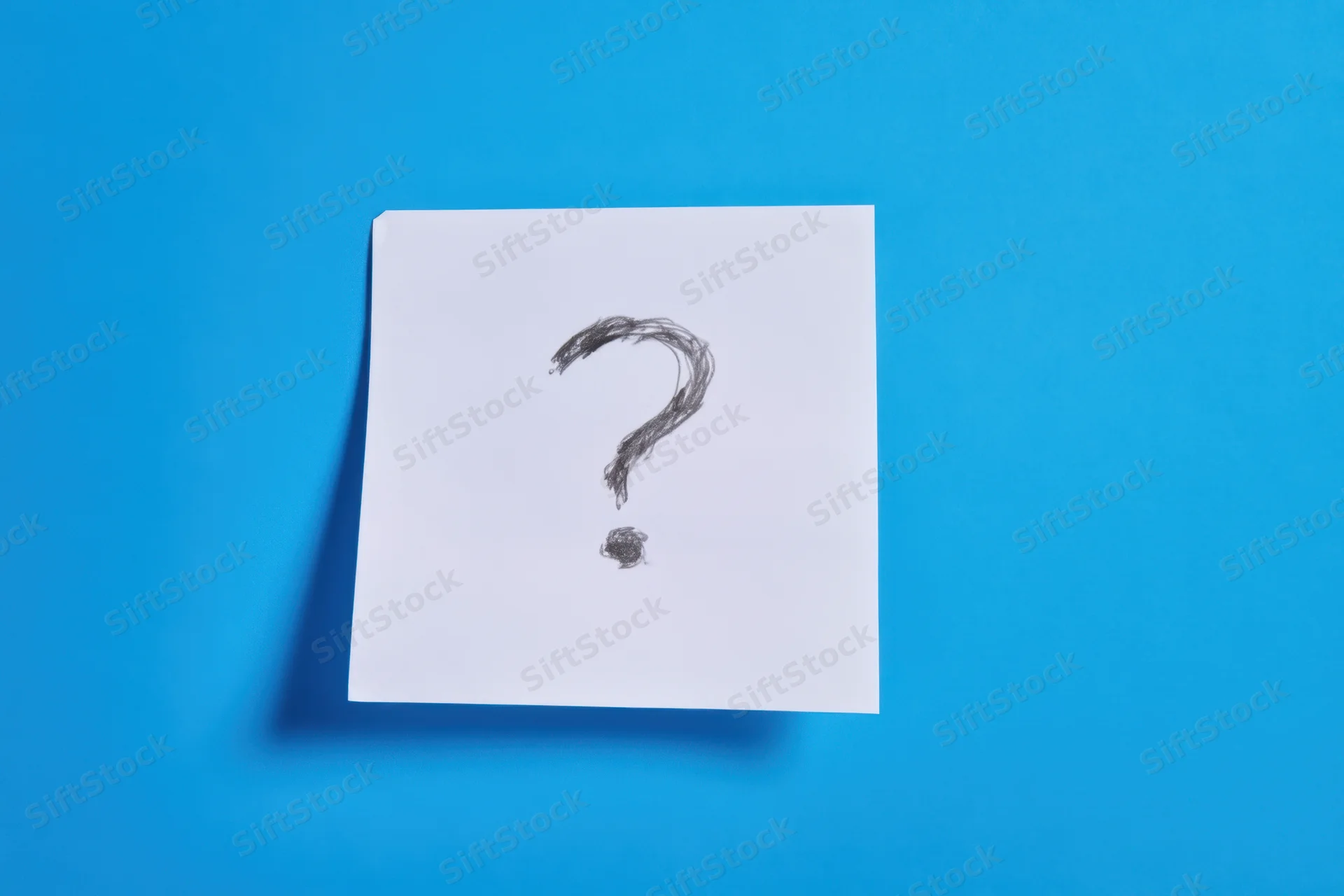 Handdrawn question mark on a white paper note against a blue background