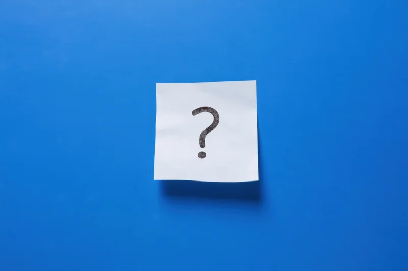 White paper note with question mark symbol on blue background