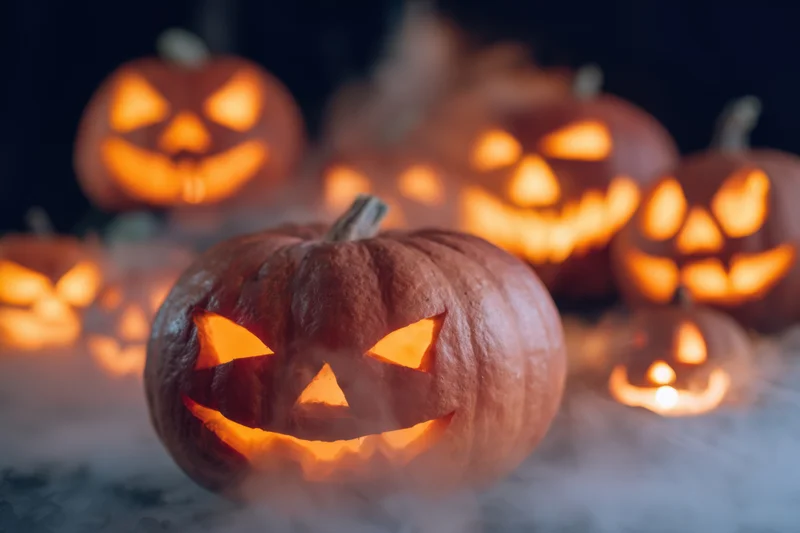 Glowing carved pumpkins arranged on a smoky surface at night for halloween decoration