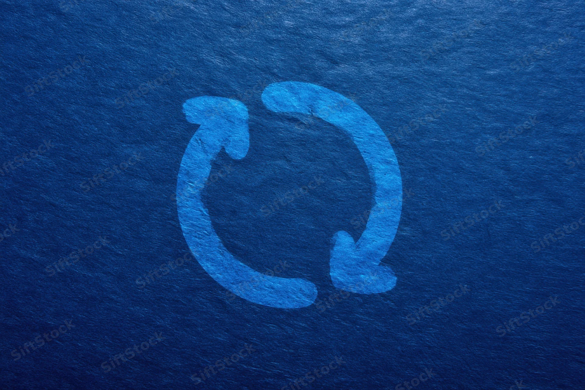 Circular recycling symbol with two arrows on a dark blue textured background