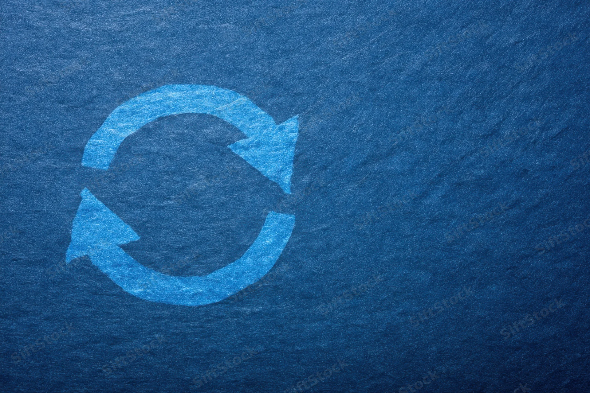 Circular recycling symbol on textured dark blue background with copyspace