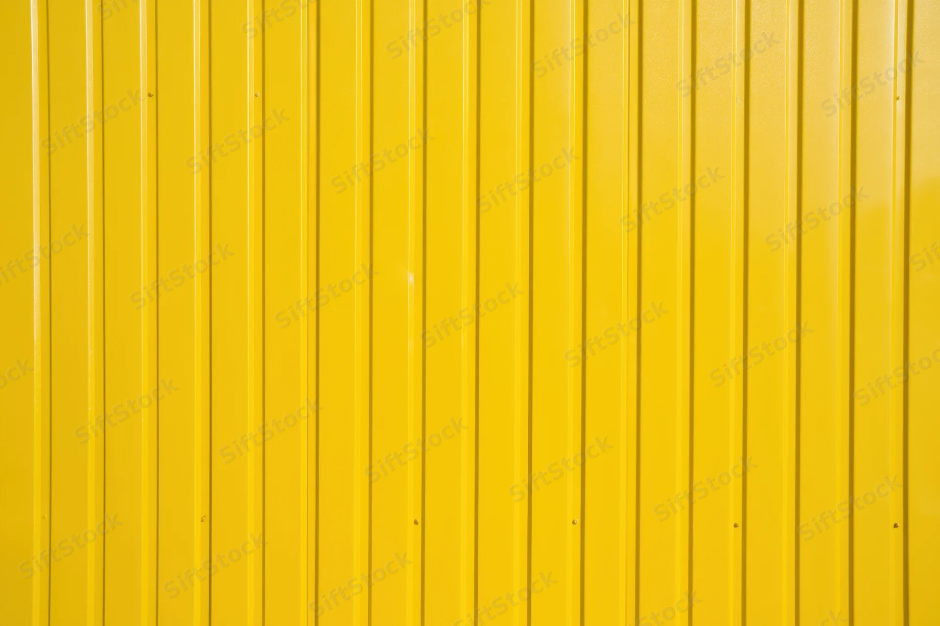 Vibrant yellow corrugated metal wall with vertical panels forming a uniform exterior surface