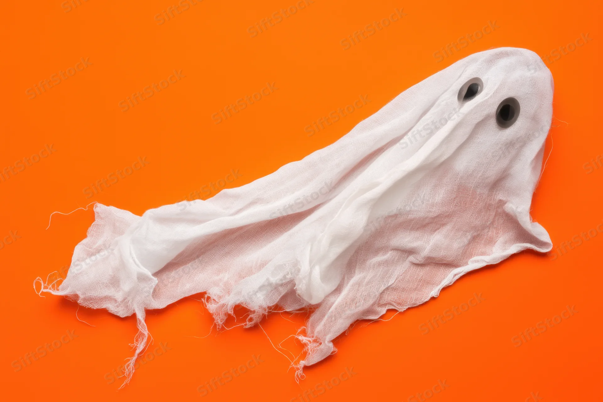 Whimsical ghost made of flowing tattered white sheet on orange background