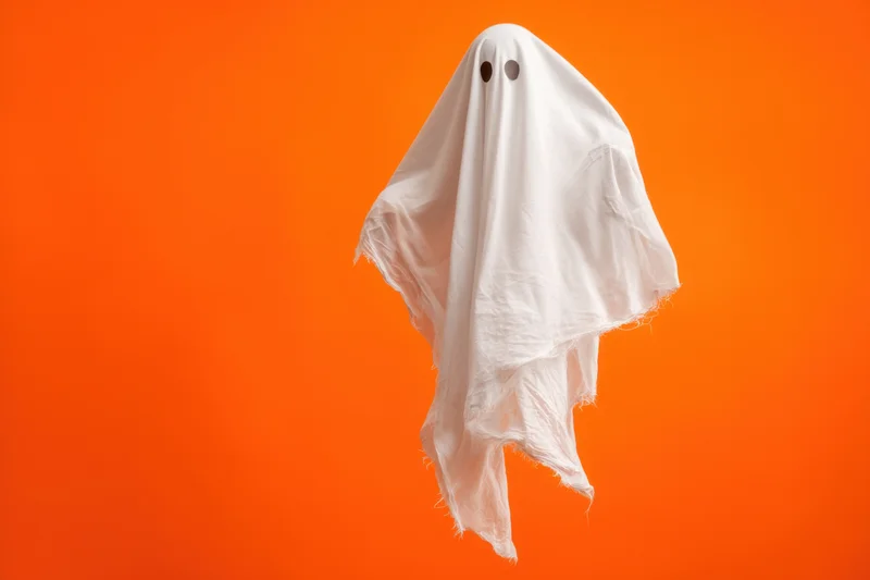 Whimsical ghost floating in a tattered white sheet against orange background