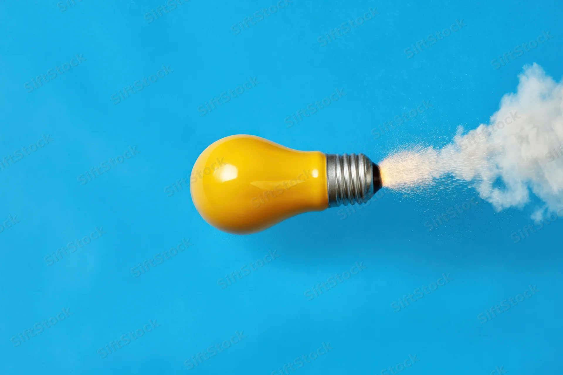 Yellow lightbulb launching like a rocket with smoke trail against blue background