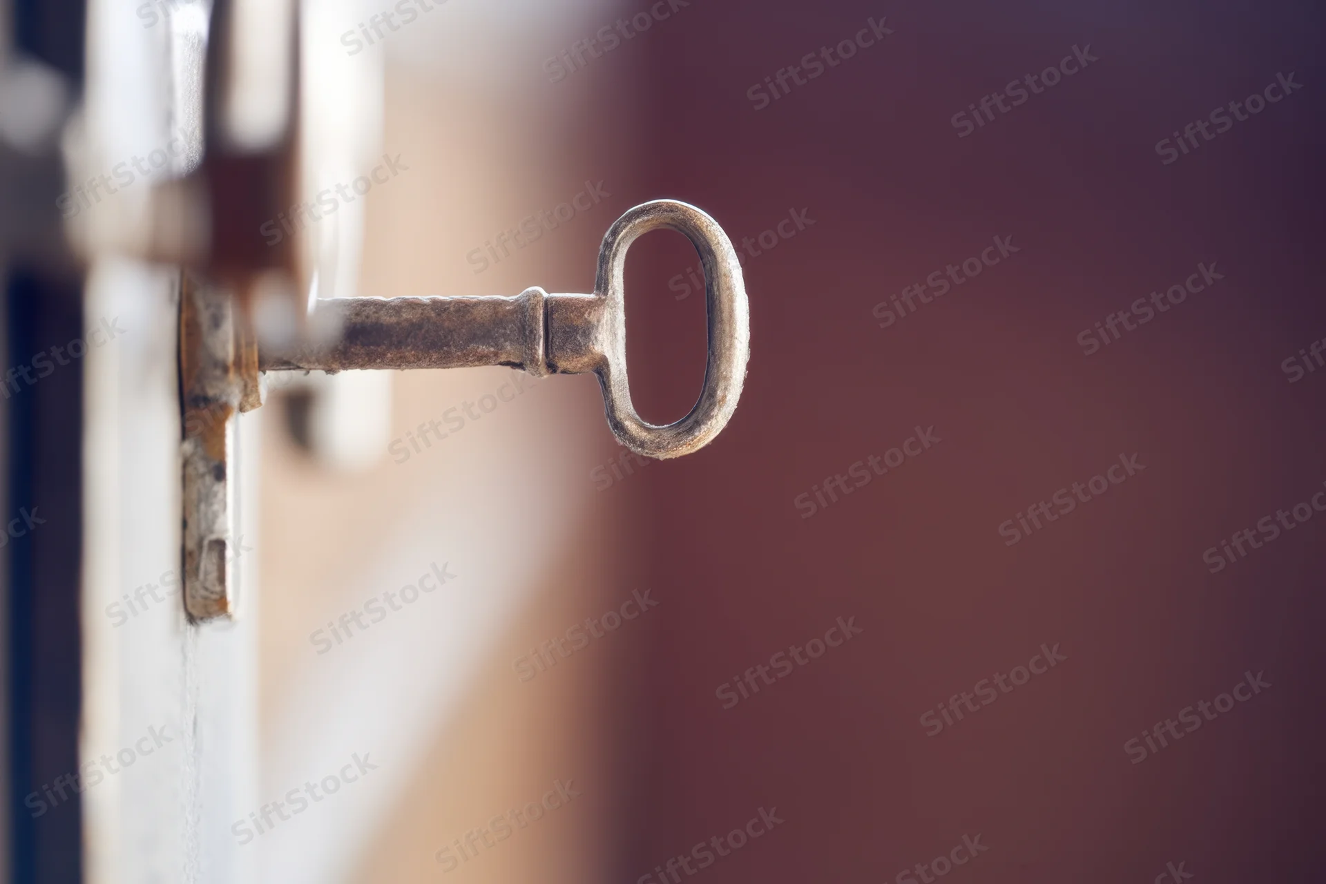 Ornate vintage key inserted into a door lock with blurred background