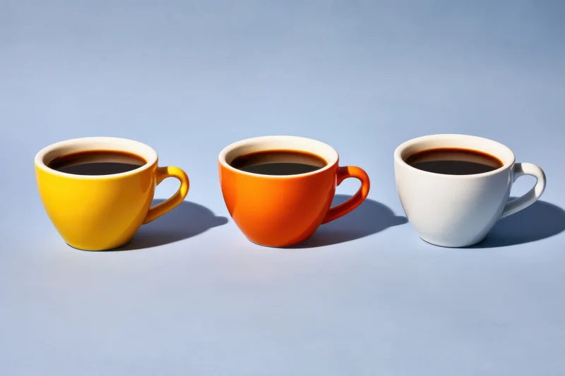 Three coffee cups in yellow, orange, and white arranged in a row on a blue background