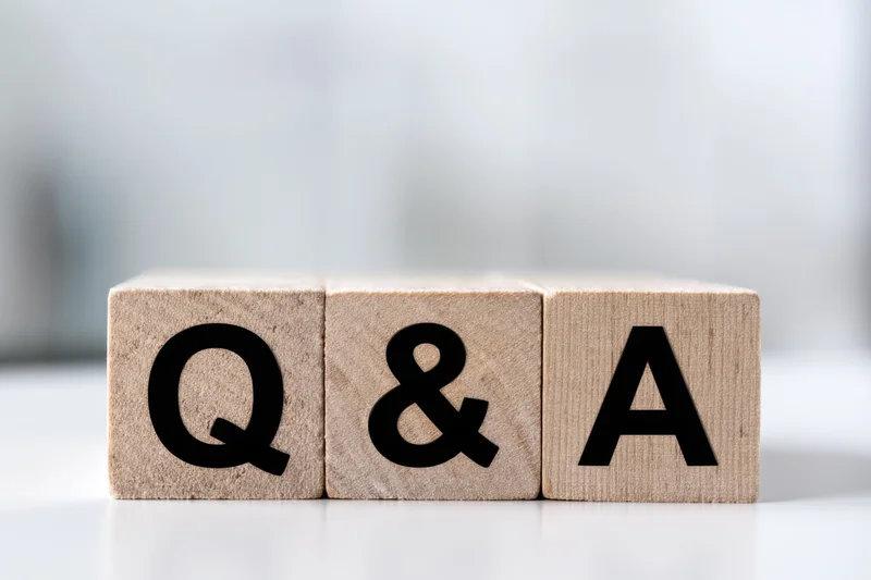 Wooden blocks with bold black letters spelling q and a arranged in a row on a white surface