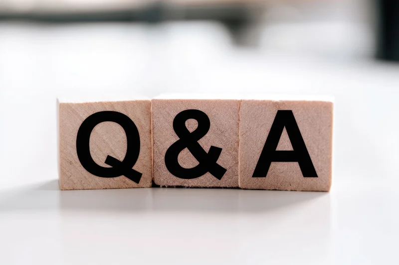 Wooden blocks with bold black letters spelling q&a arranged neatly on a white surface