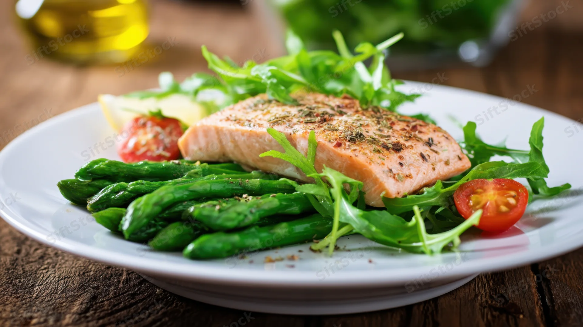 Grilled salmon fillet with asparagus and arugula salad on a white plate