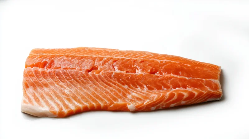 Fresh salmon fillet resting on a clean white surface