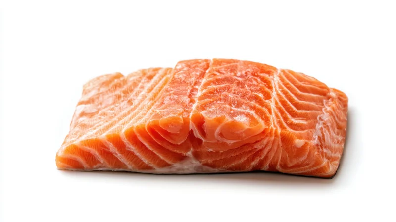 Fresh salmon fillet resting on a clean white surface