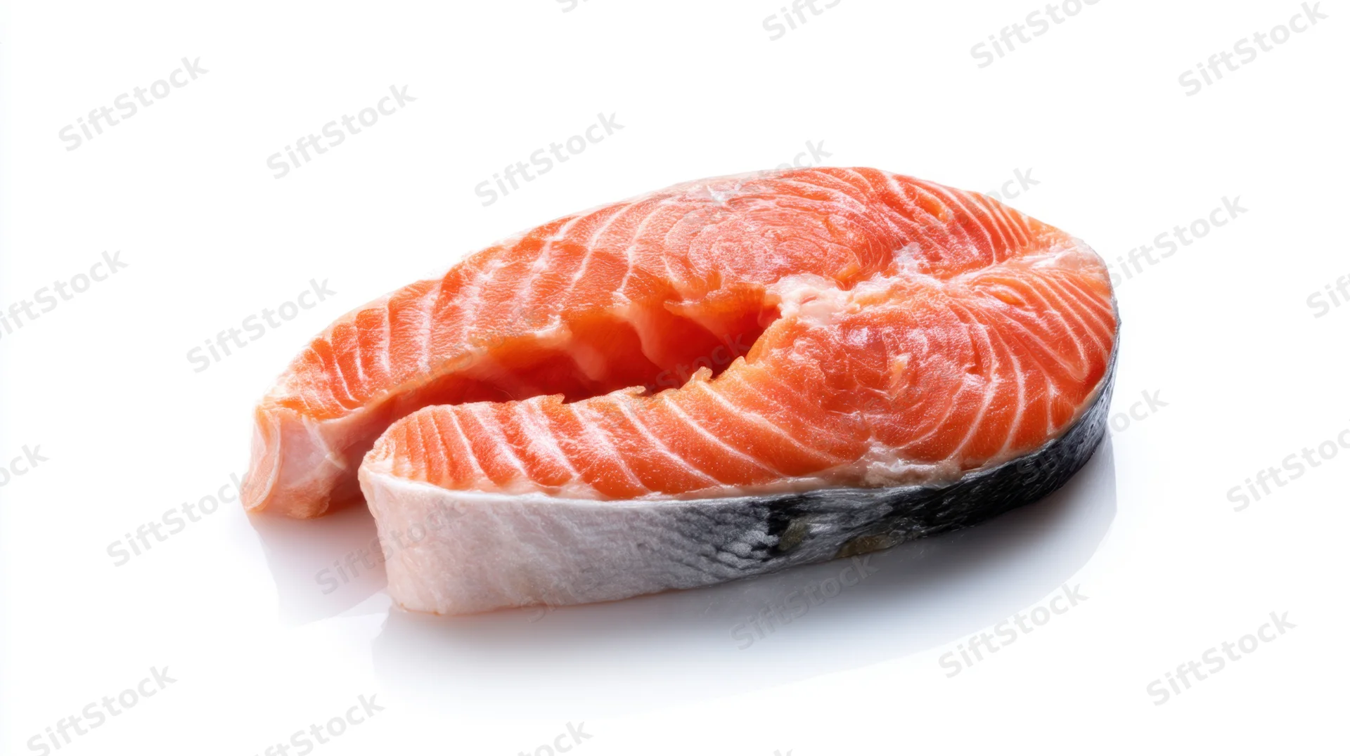 Fresh raw salmon steak with vibrant pink-orange flesh on white background