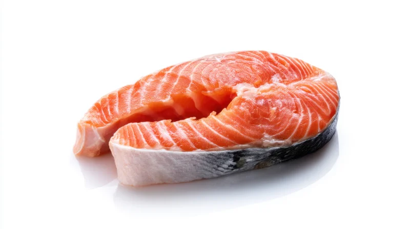 Fresh raw salmon steak with vibrant pink-orange flesh on white background