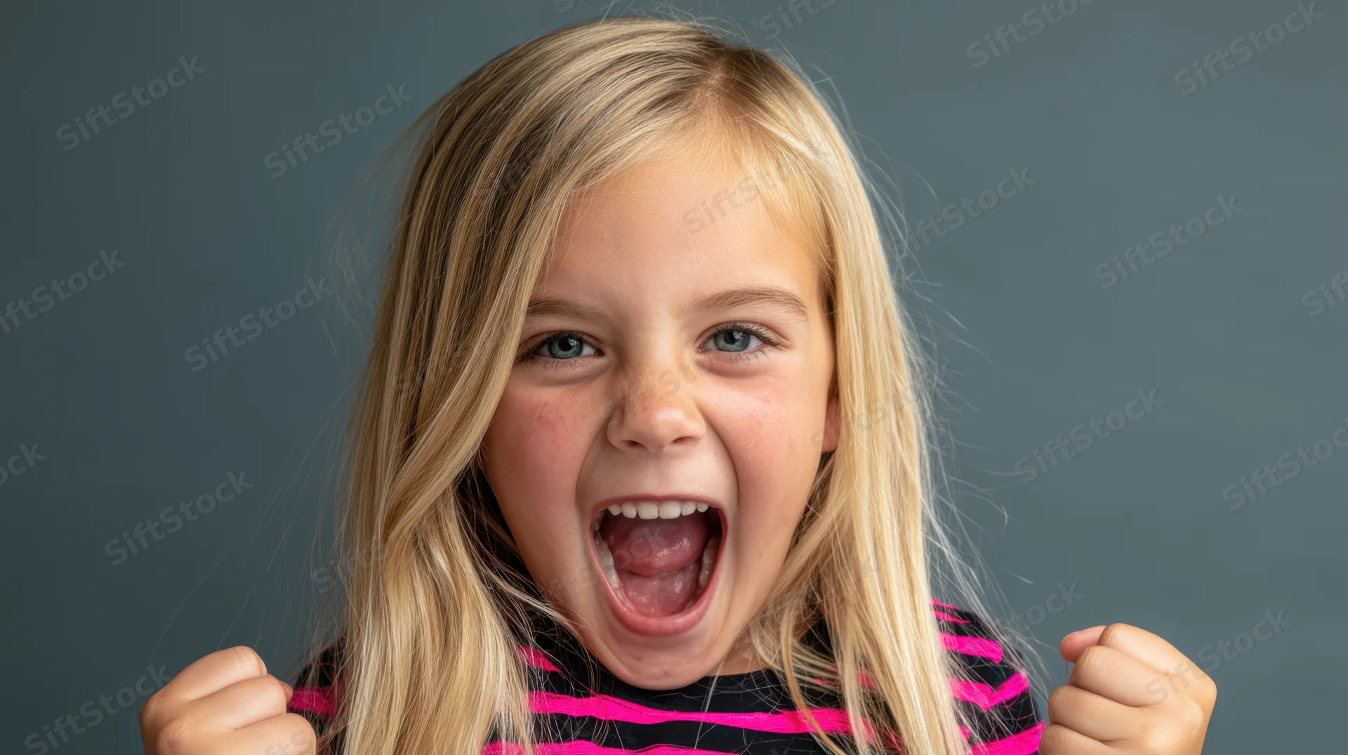Young girl with long straight blonde hair shouting excitedly in studio portrait