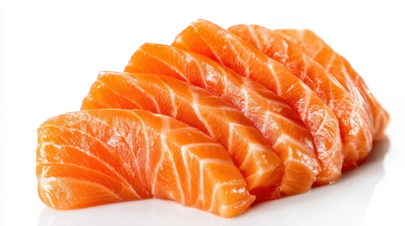 Neatly arranged slices of raw salmon sashimi on white background