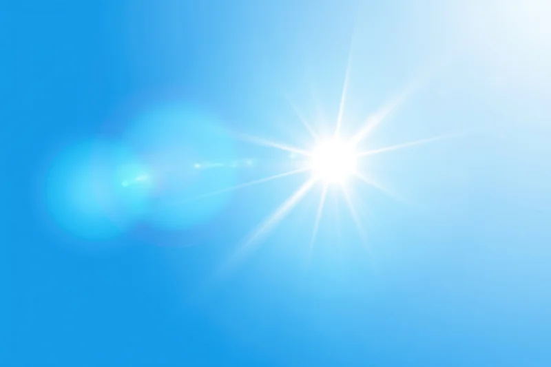 Bright sun shining on a blue gradient background with lens flare and soft glow