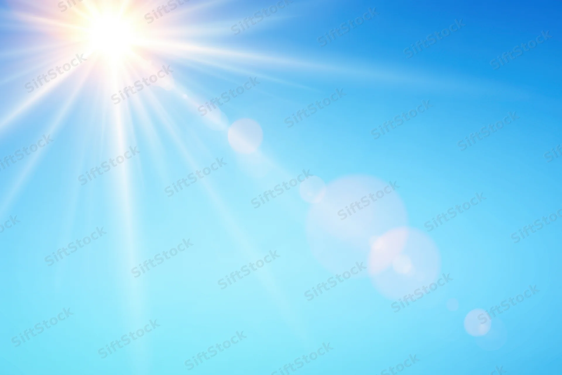 Bright sun shining in a clear blue gradient sky with lens flare and bokeh effects