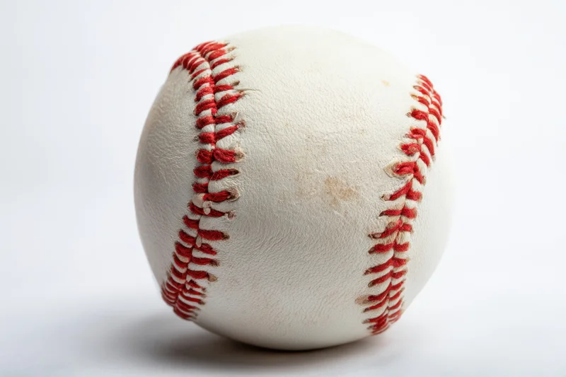 A classic baseball with detailed red stitching resting on a white surface