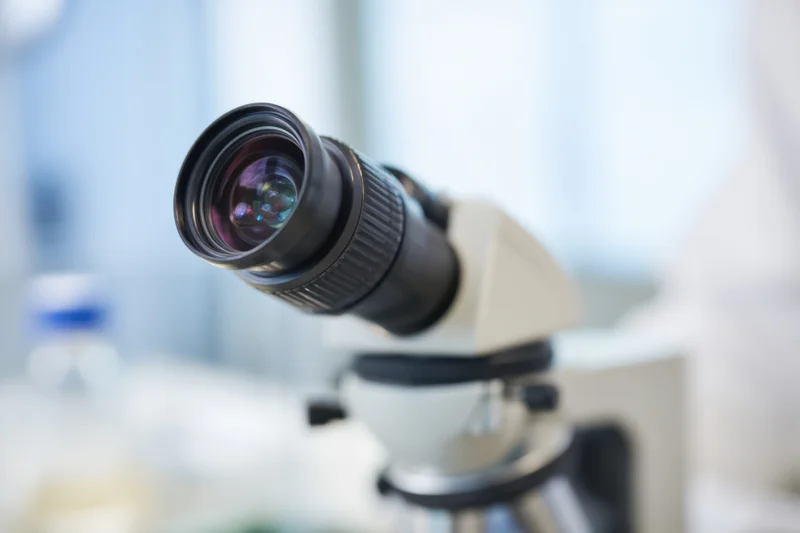 Close-up of a microscope lens in a laboratory setting