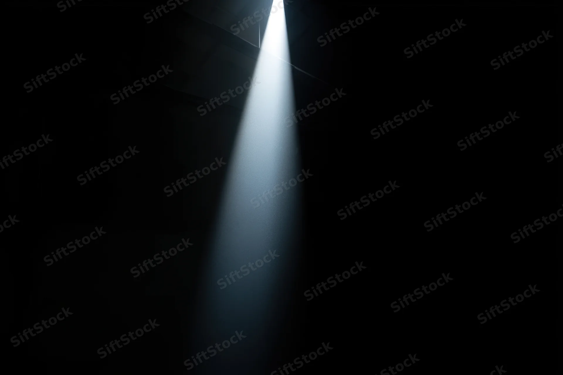 A focused beam of light cutting through a dark interior space
