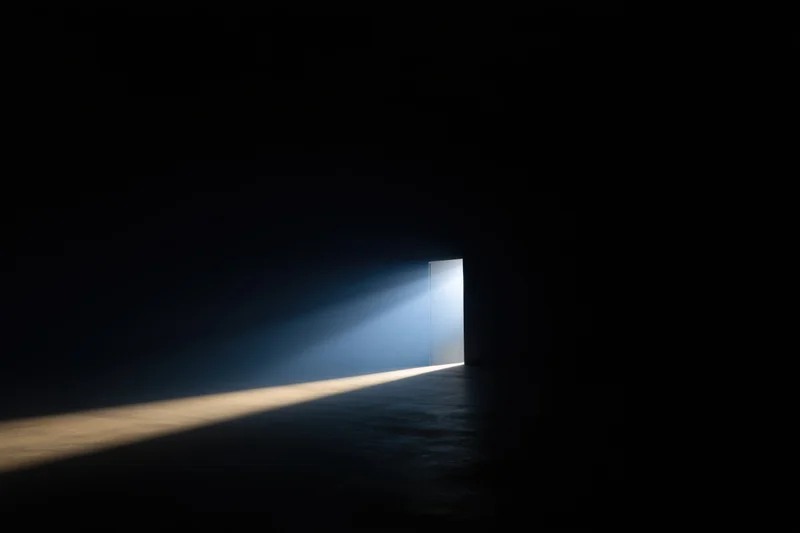 A beam of light cutting through a dark interior space from an open doorway