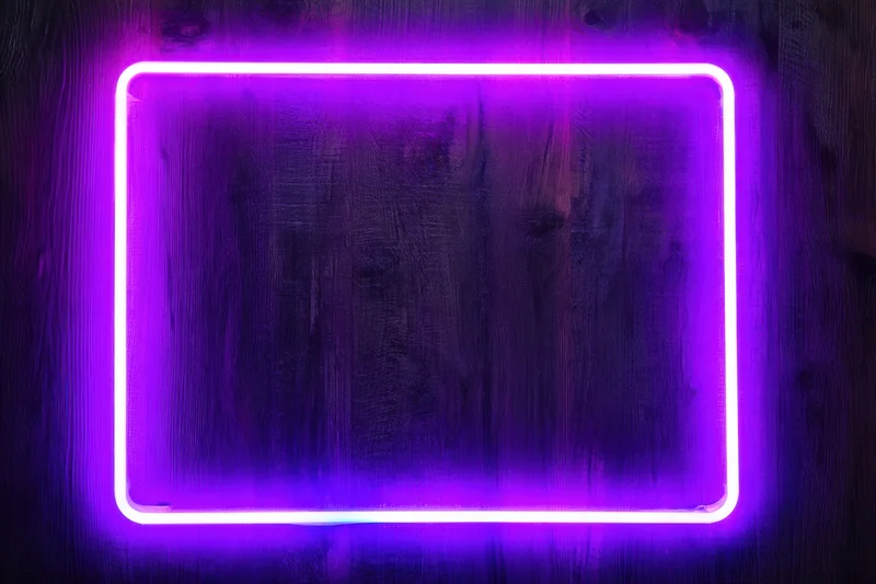 Glowing neon purple frame mounted on textured wooden wall