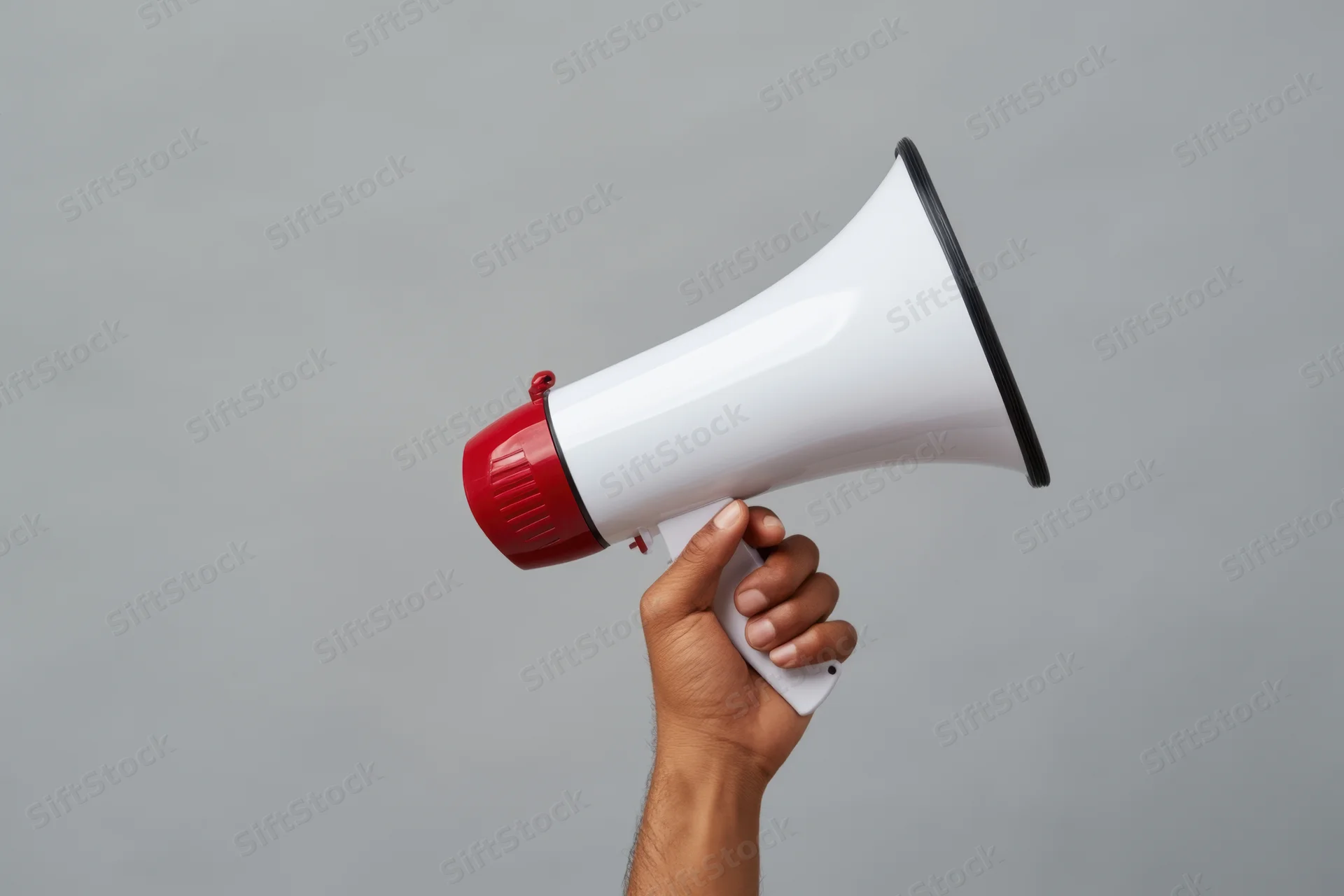 Hand holding a white and red megaphone against a gray background