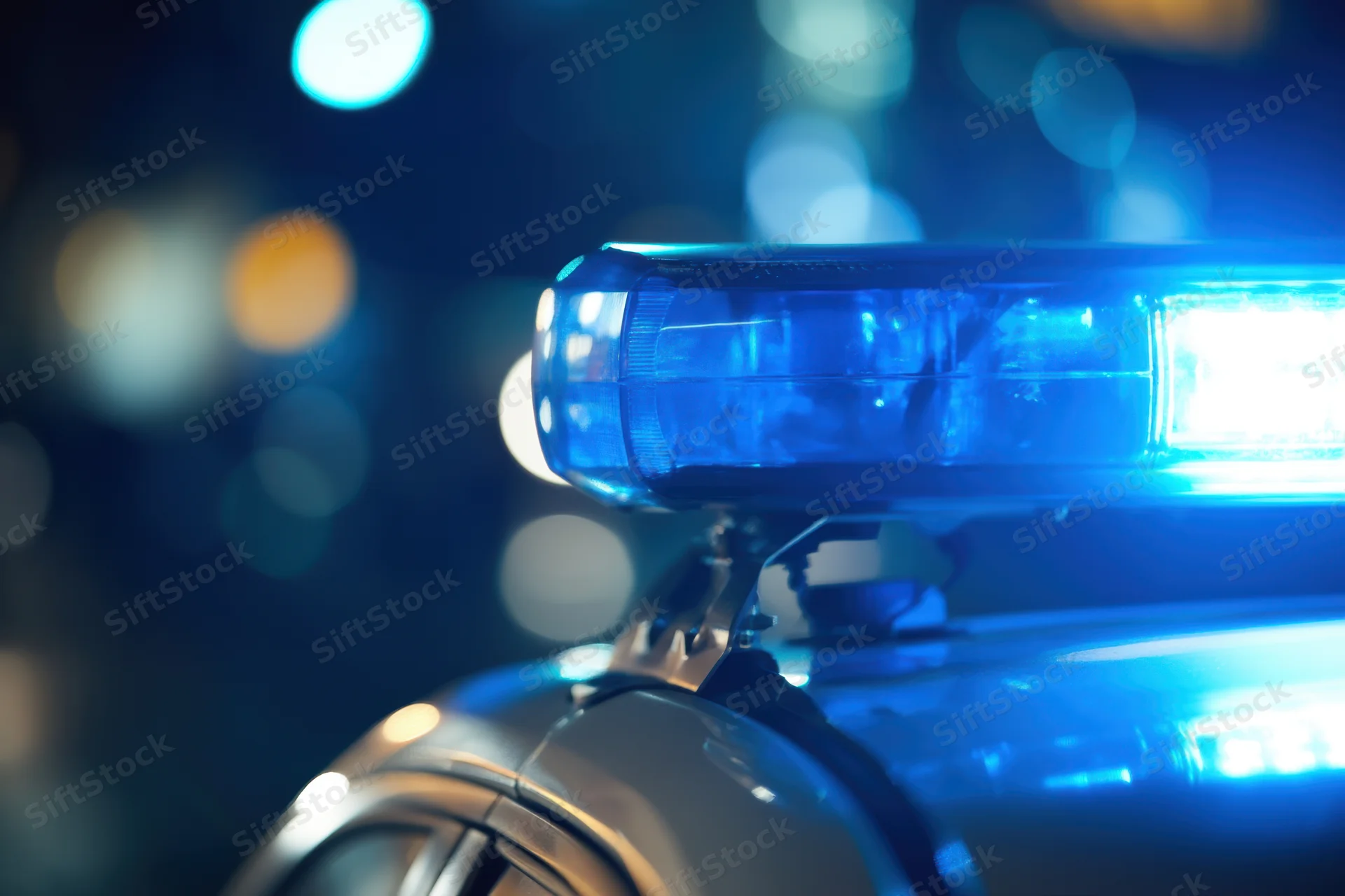 Close-up of flashing blue police light on vehicle roof at night