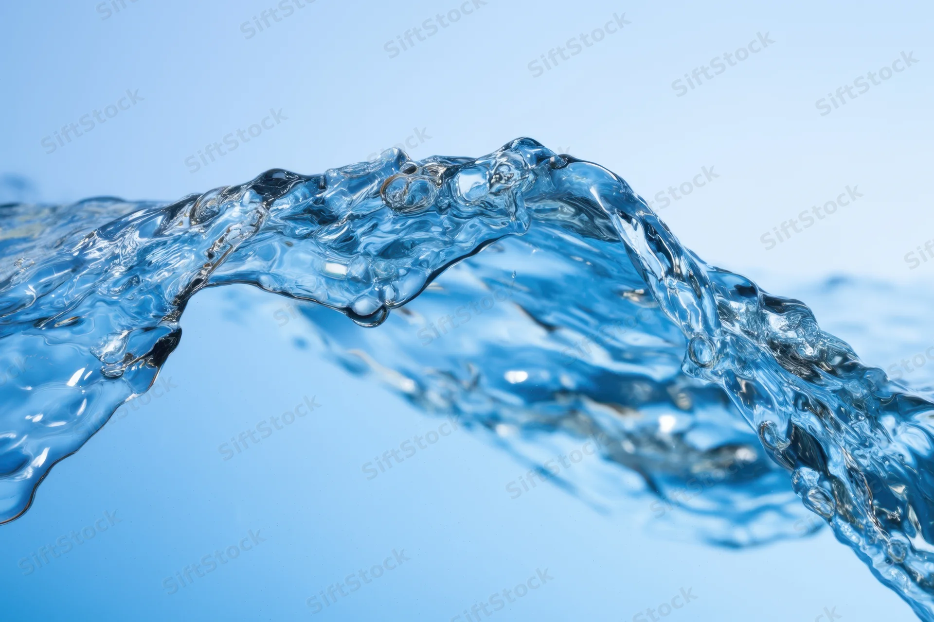 Clear blue water forming a dynamic wave splash against a light blue background