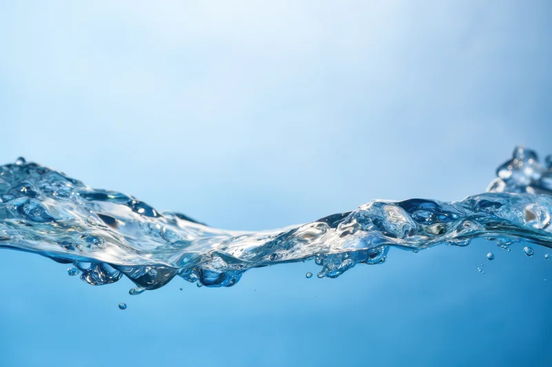 Clear blue water surface with gentle ripples and bubbles against a light blue background
