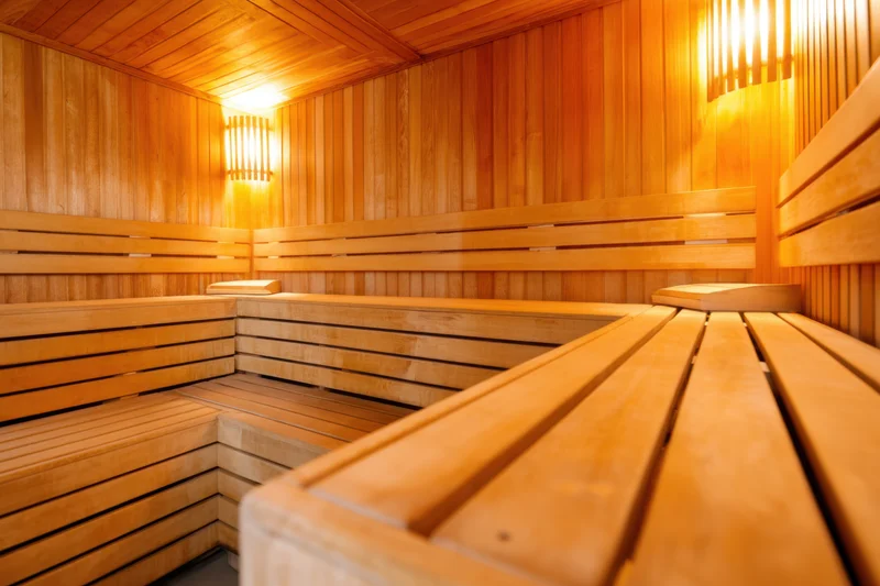 Wooden sauna interior with tiered benches and warm ambient lighting