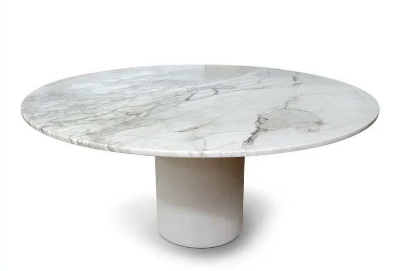 Round marble dining table with polished white surface and cylindrical pedestal base isolated on white