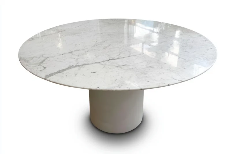 Round white marble dining table with polished surface and cylindrical pedestal base isolated on white