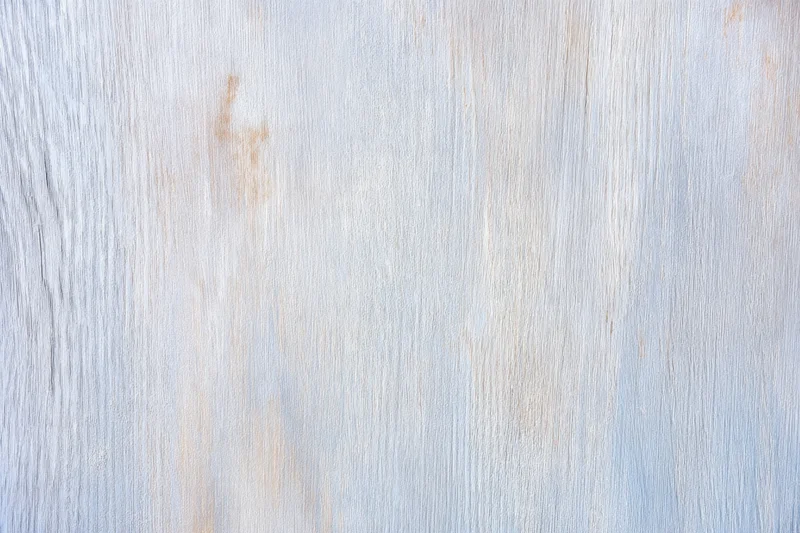Smooth weathered wood surface with visible grain and light natural finish