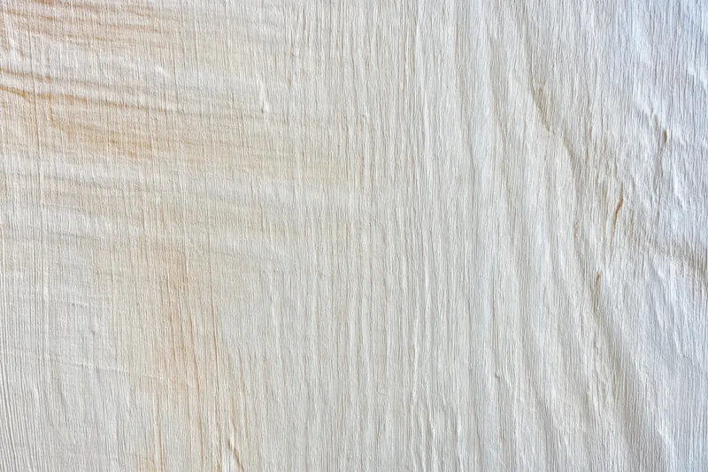 Smooth light weathered wood surface with visible grain pattern filling the frame