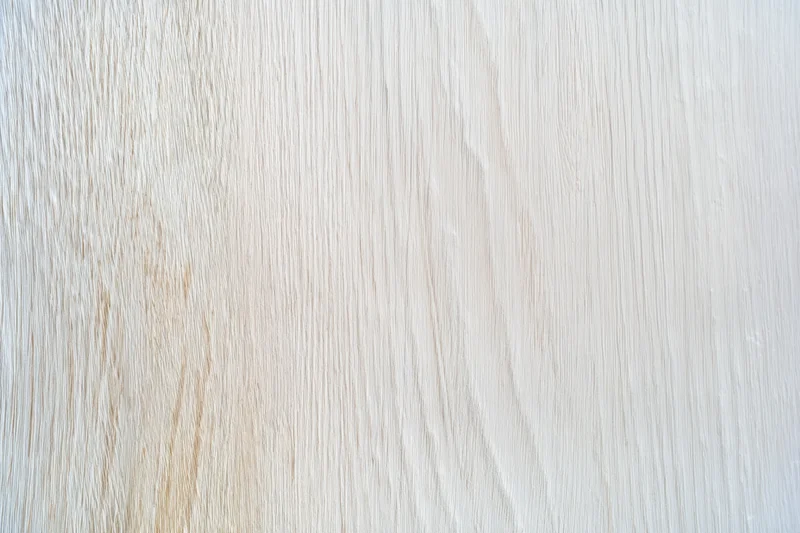 Smooth light weathered wood surface with visible grain pattern