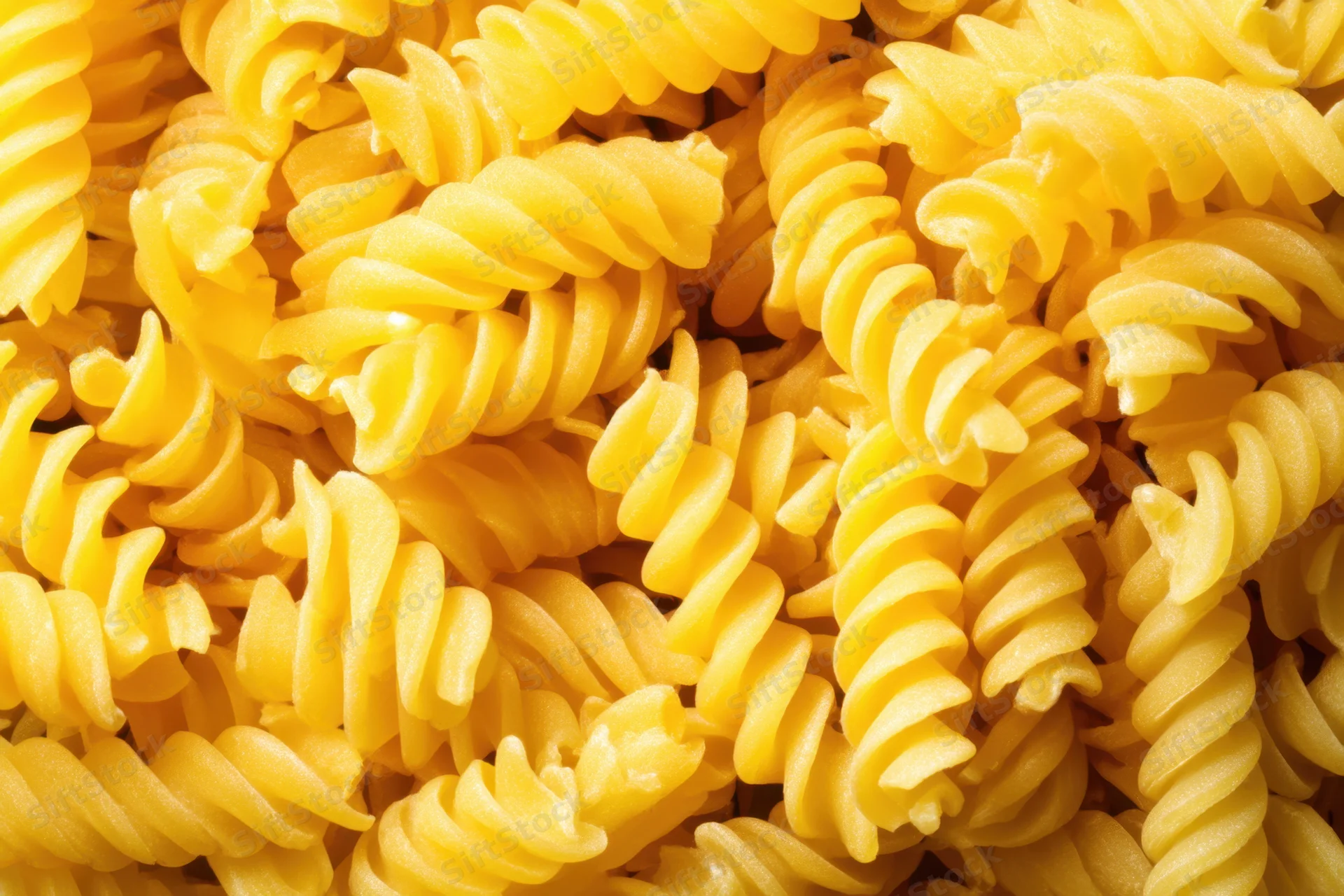 Tightly packed uncooked spiral pasta filling the frame
