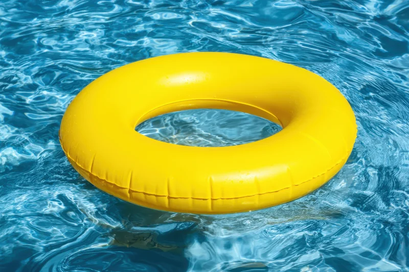 Yellow inflatable pool float bobbing in clear blue water