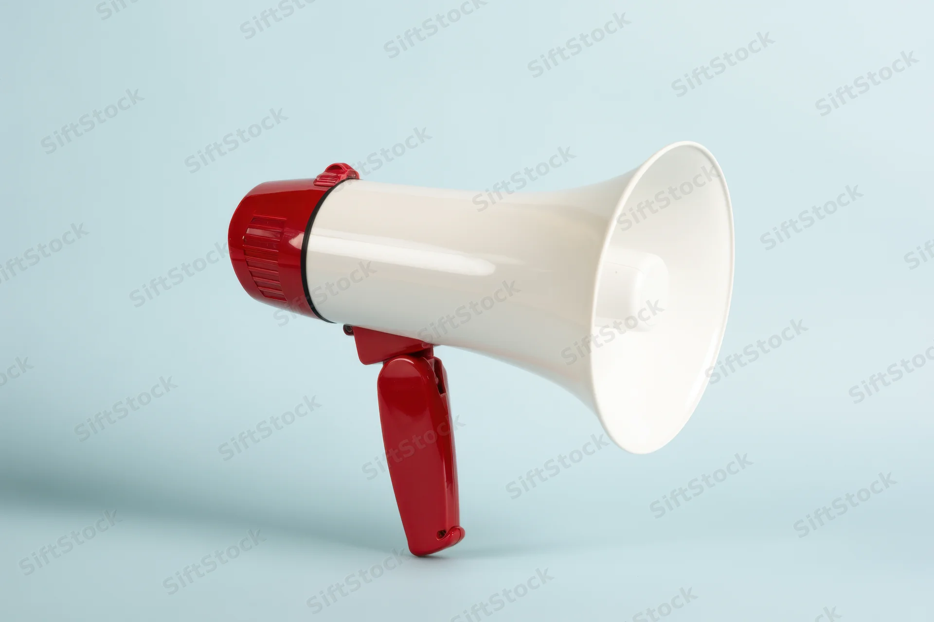 White megaphone with red handle positioned against a light blue background