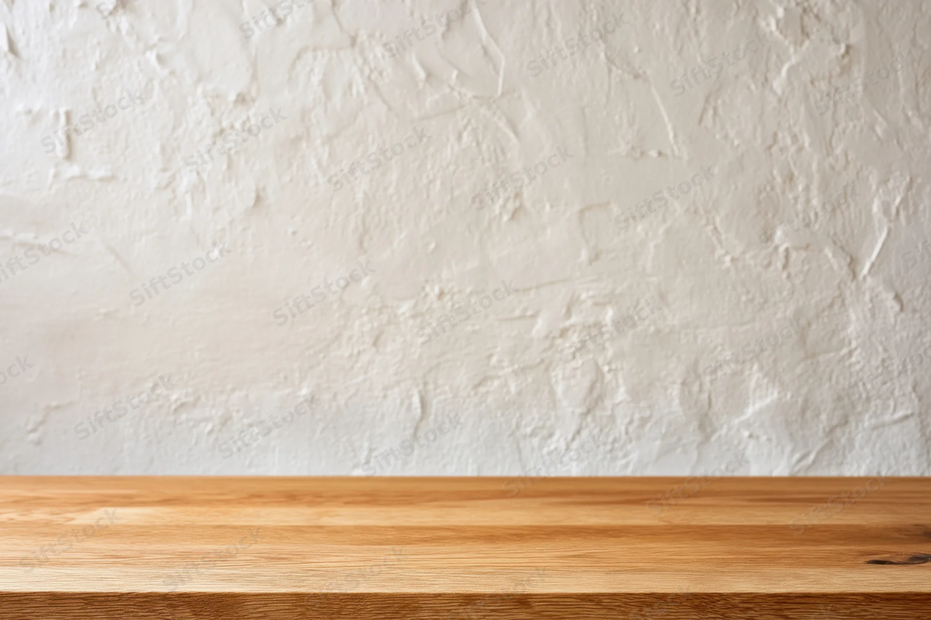 Wooden table with smooth natural finish against textured white wall