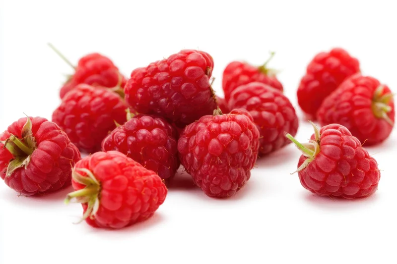 Fresh ripe raspberries scattered on a white background with copyspace