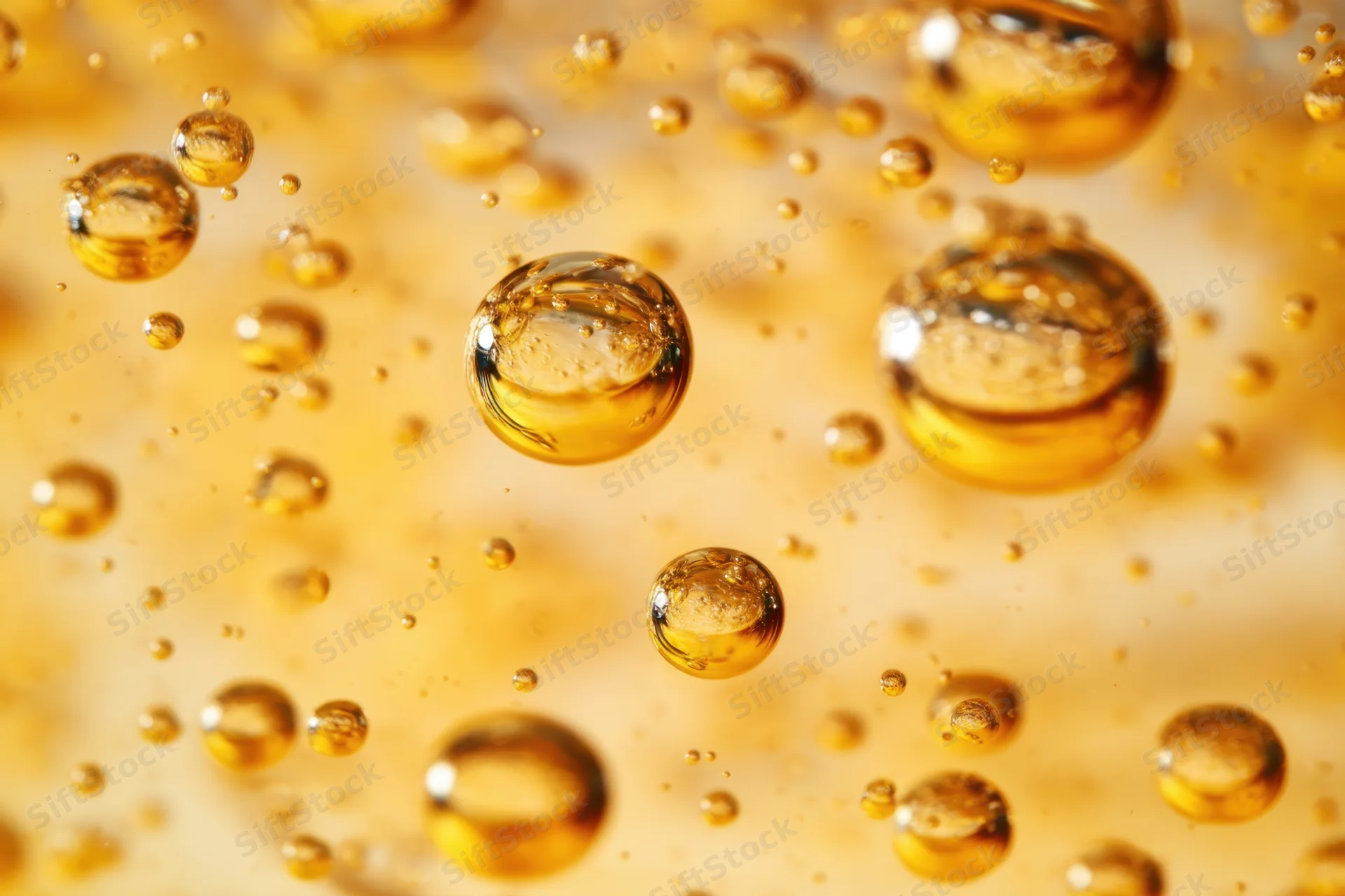 Golden bubbles floating in a liquid with soft blurred background