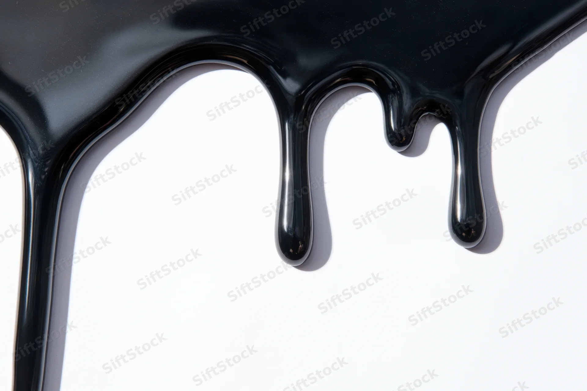 Glossy black paint dripping down a white surface